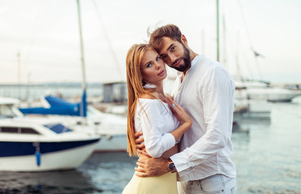 Beautiful couple in love spending time together in the yacht club - Photo, Image