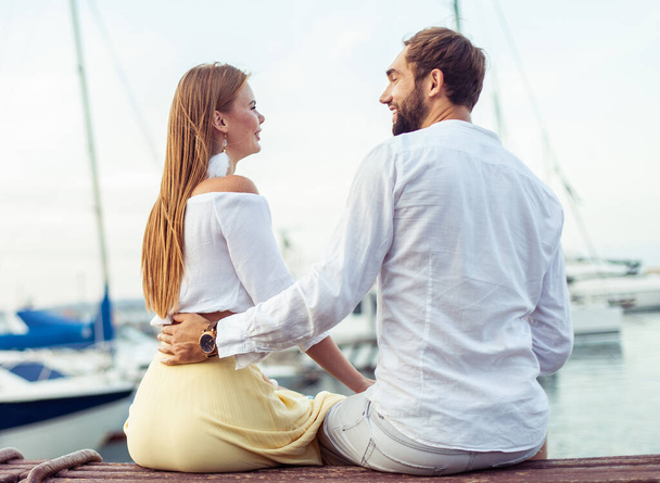 Beautiful couple in love spending time together in the yacht club - Photo, Image