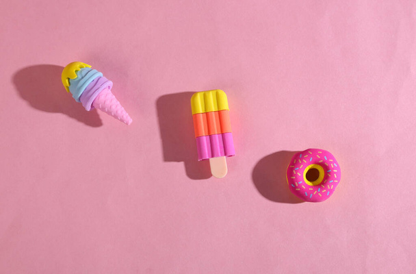 Modelo plástico de um donut e sorvete em fundo rosa - Foto, Imagem