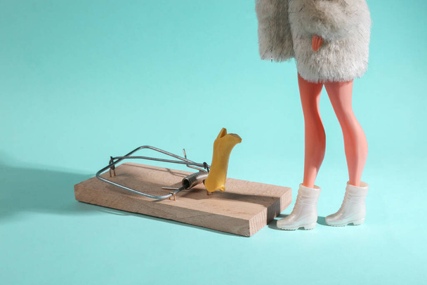 Una oferta tentadora. Culto de compras. Venta. La muñeca está de pie cerca de la ratonera con nuevas botas sobre un fondo azul. Diseño mínimo - Foto, imagen