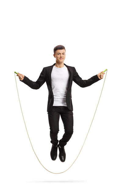 Full length portrait of a young stylish guy skipping a rope isolated on white background - Zdjęcie, obraz