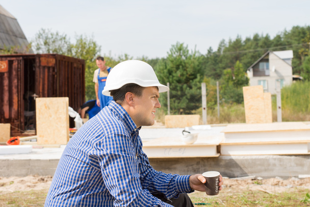 Жаждущий строитель берет перерыв на кофе
 - Фото, изображение