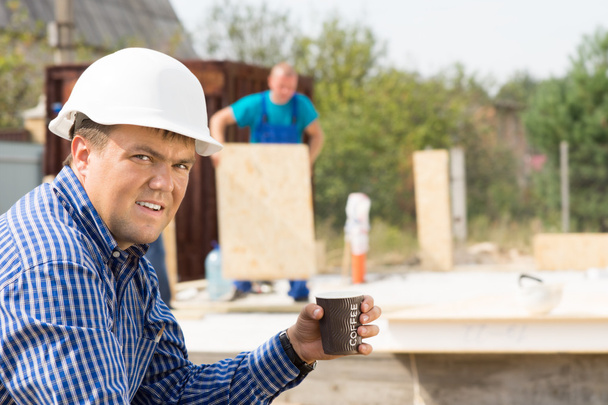 Ingeniero masculino sosteniendo taza de café en el sitio
 - Foto, imagen