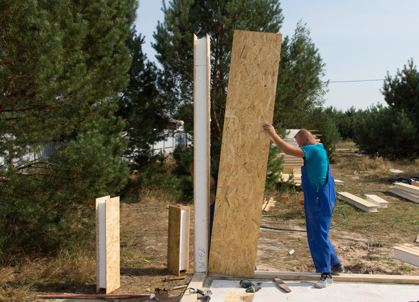 Worker erecting wall panels on a building site - Foto, Imagen