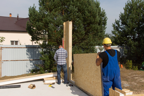 Workmen erecting wall insulation panels - Foto, afbeelding