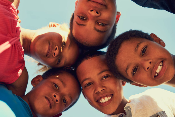 Des misères pour toujours. Portrait d'un groupe d'enfants debout bras dans le bras dans un câlin à l'extérieur. - Photo, image