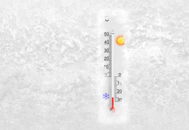 Outdoor thermometer on a frozen window shows minus 25 degrees celsius temperature in cold winter day - Фото, изображение
