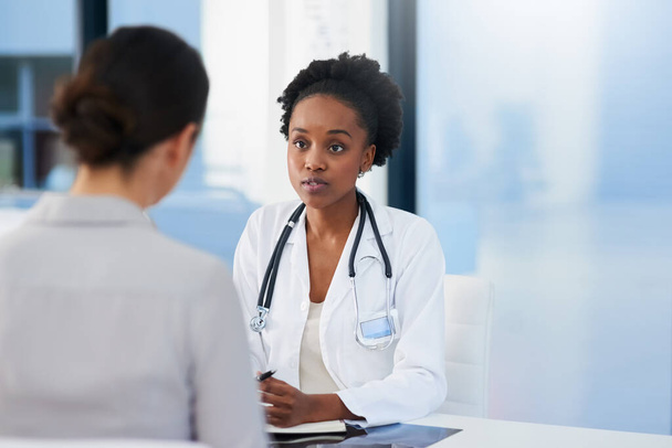 Bilmem gereken herhangi bir belirti var mı? Kadın bir doktorun, ofisinde bir hastayla konuşurken çekilmiş bir fotoğrafı.. - Fotoğraf, Görsel