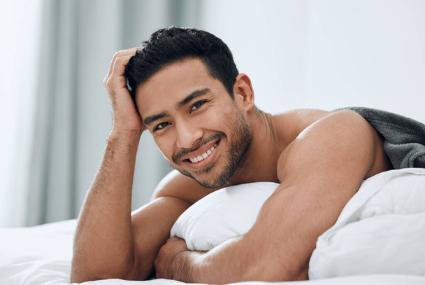 The bedroom is my happy place. Shot of a handsome young man lying on his bed. - Photo, Image