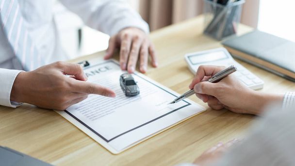 Concept d'assurance le concessionnaire masculin suggérant à son client de signer le contrat d'achat de voiture. - Photo, image