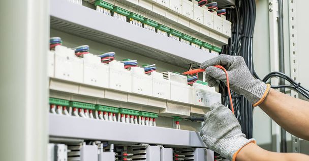 Elektrotechniker prüft den Betrieb des Schaltschranks regelmäßig für Wartungsarbeiten. - Foto, Bild