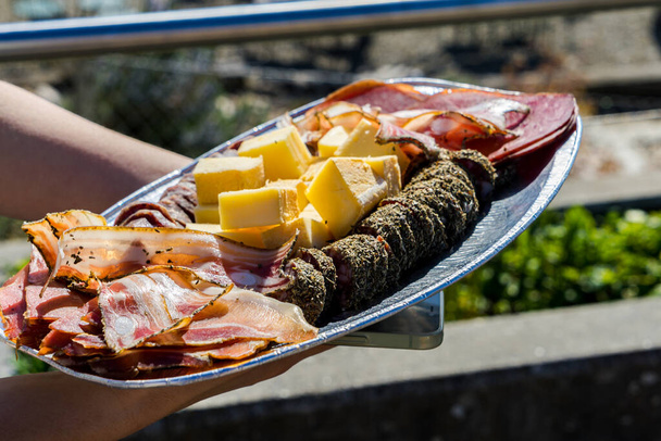 Sliced deli meats and cheeses against the backdrop of Lake Geneva - Photo, Image