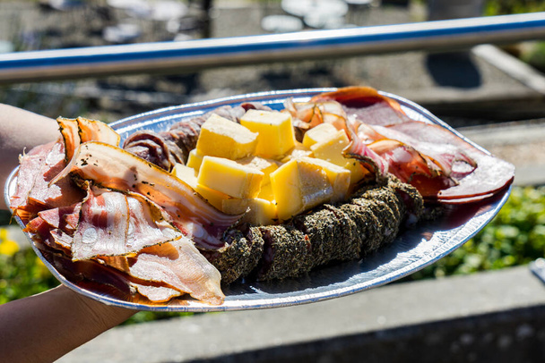 Sliced deli meats and cheeses against the backdrop of Lake Geneva - Photo, Image