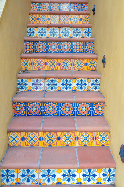 Scala con mattonelle ornate montanti e gradini con piastrelle a San Francisco, California. Scale strette al centro di due pareti dipinte di giallo. - Foto, immagini