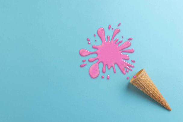 Dropped ice cream on cyan surface concept. Spilled pink cream. Top view, flat lay composition - Foto, Imagen