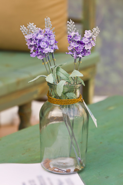 Violetti kukkia lasipannulla
 - Valokuva, kuva