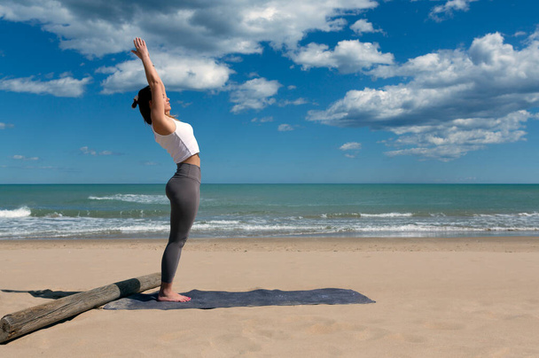 young female athlete performing pilates at the seashore - Foto, Bild
