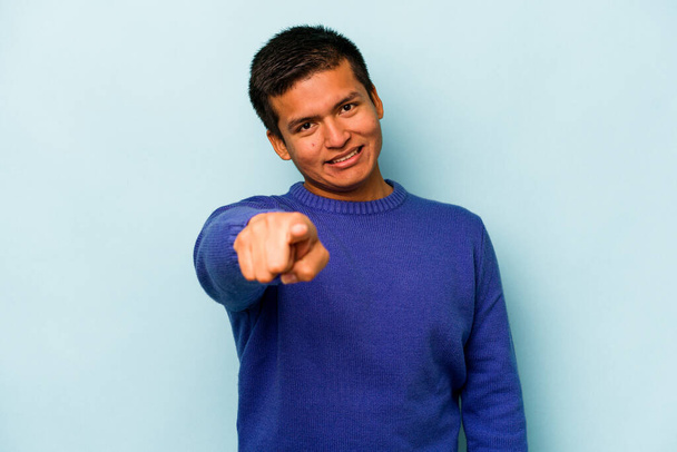 Young hispanic man isolated on blue background cheerful smiles pointing to front. - Photo, Image