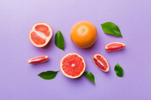 fresh Fruit grapefruit with Juicy grapefruit slices on colored background. Top view. Copy Space. creative summer concept. Half of citrus in minimal flat lay with copy space. - Photo, Image