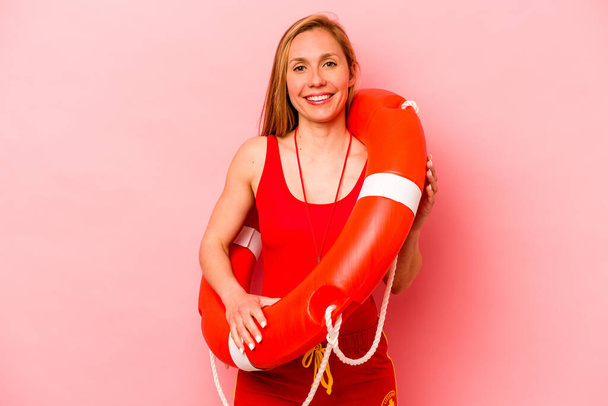 Junge kaukasische Rettungsschwimmerin isoliert auf rosa Hintergrund glücklich, lächelnd und fröhlich. - Foto, Bild