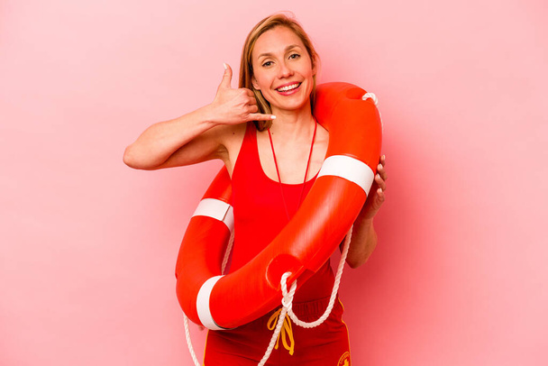 Young caucasian life guard woman isolated on pink background showing a mobile phone call gesture with fingers. - Photo, Image