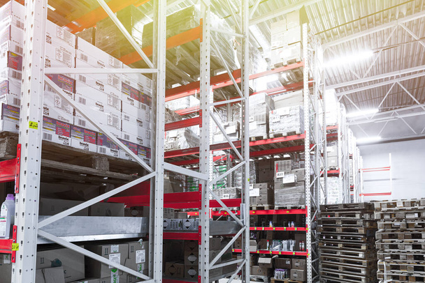 estantes altos en un almacén logístico lleno de mercancías - Foto, Imagen