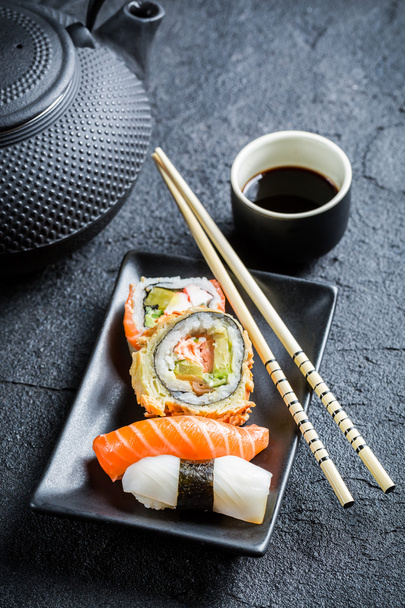 Closeup of fresh sushi served in with tea - Фото, зображення