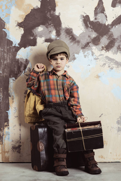 Boy sitting on luggage with books, retro shot, 50s-60s - Foto, Imagem