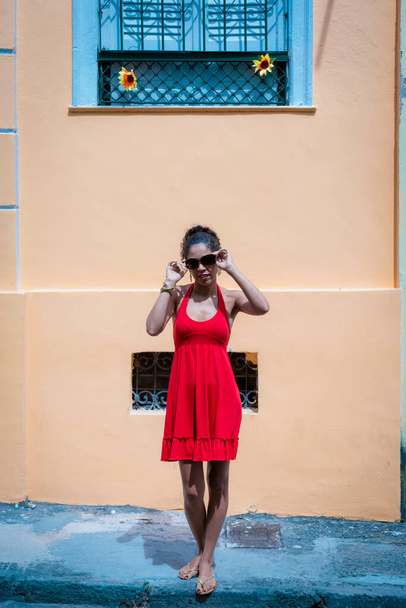 Portrait of a woman wearing red clothes on the street in bright sunny day. Salvador, Bahia, Brazil. - Foto, Imagen