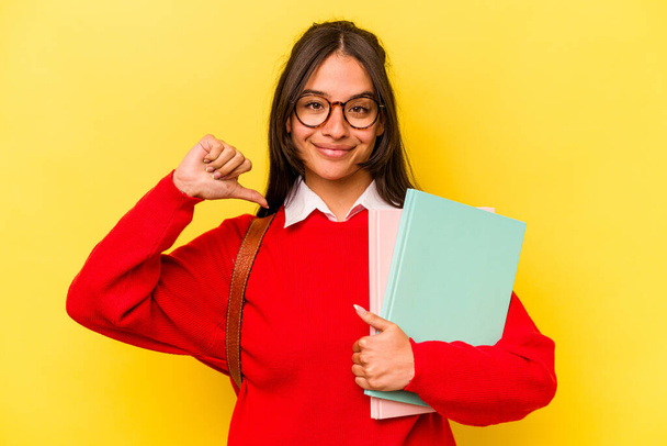 Junge Studentin hispanische Frau isoliert auf gelbem Hintergrund fühlt sich stolz und selbstbewusst, Beispiel zu folgen. - Foto, Bild