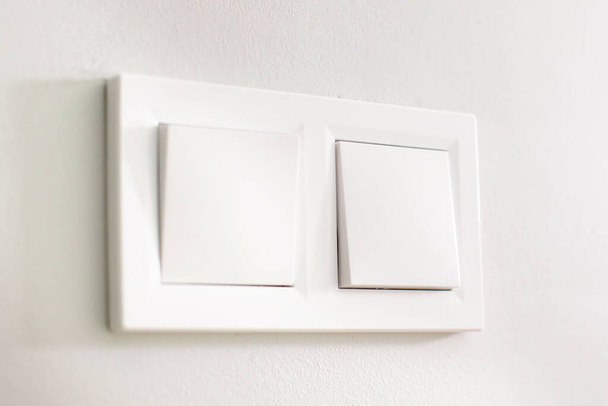 Light switches, white plastic mechanical switches mounted on white walls. - Foto, Bild