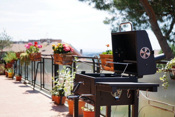 Barbecue on the terrace with many flowers and a beautiful view - Foto, Imagen