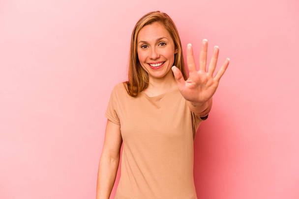 Молодая белая женщина, изолированная на розовом фоне улыбаясь весело показывая номер пять пальцами. - Фото, изображение