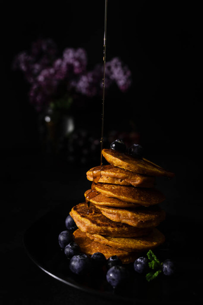 Homemade pancakes with maple syrup and fresh blueberries. Homemade and healthy breakfast with dark background. Gluten free carrot pancakes - Zdjęcie, obraz