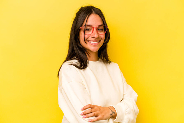 Young hispanic woman isolated on yellow background happy, smiling and cheerful. - 写真・画像