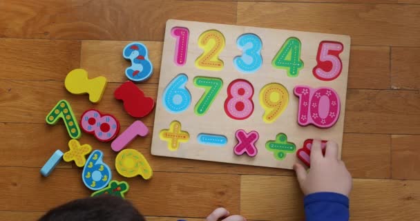  Κάτοψη ενός παιδιού που παίζει σε αριθμητικό πίνακα στο πάτωμα. - Πλάνα, βίντεο