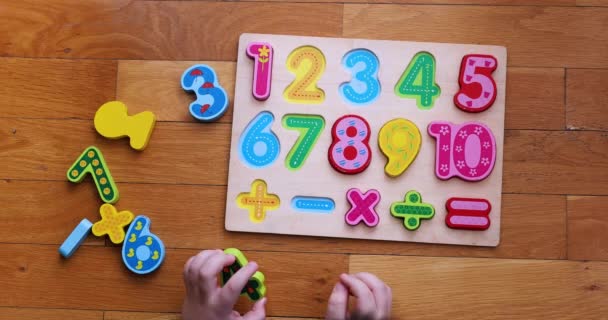  Bovenaanzicht van een kind dat op numeriek bord op de vloer speelt. - Video