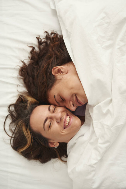 Couple heads with closed eyes under blanket on bed - Foto, Bild