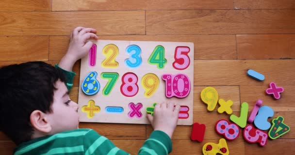  Bovenaanzicht van een kind dat op numeriek bord op de vloer speelt. - Video