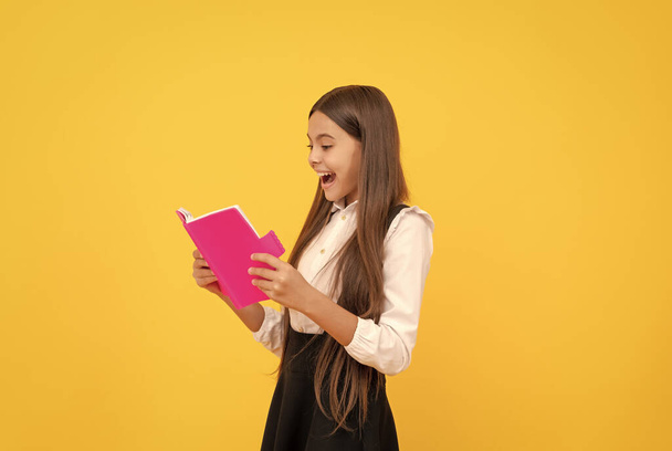 zaskoczony nastolatek dziewczyna w szkole mundur czytania książki, miłośnik książki - Zdjęcie, obraz