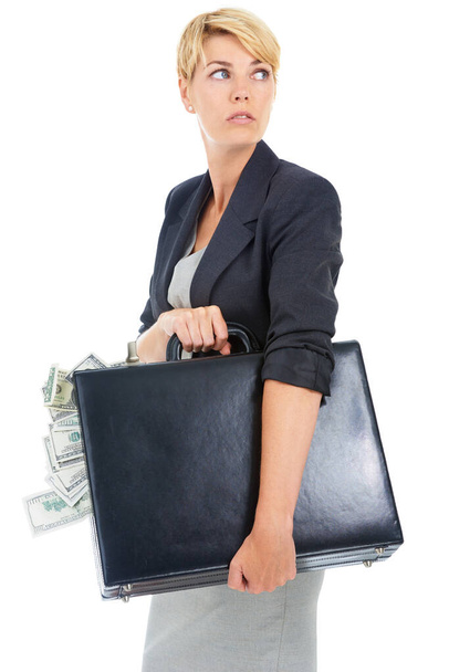 Malversación de fondos. Una joven mujer de negocios mirando alrededor mientras sostiene un maletín de dinero en efectivo. - Foto, imagen