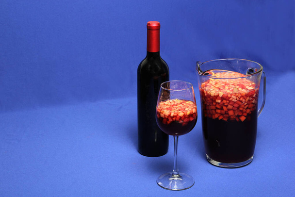 Fruit Clericot, mineral water, lemon soda, grapefruit juice, ice, sugar and a bottle of red wine, is a refreshing alcoholic drink for hot days in Latin America served in a glass pitcher and glass. - Foto, imagen