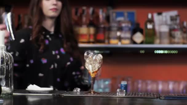 Ragazza rossa Giovane donna adulta barista prepara miscele carta aereo cocktail bar Pours campane di ghiaccio - Filmati, video