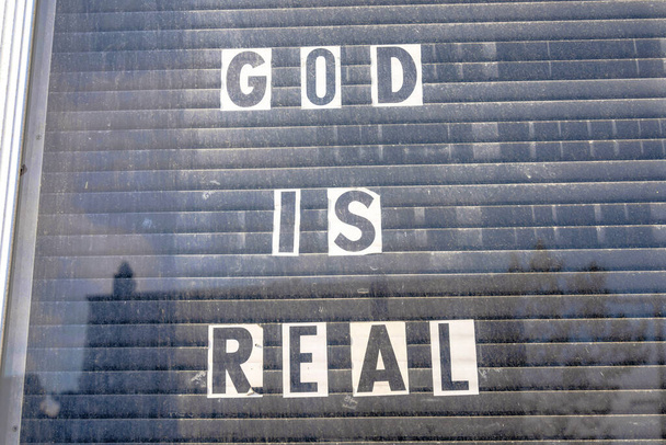 Lasi-ikkuna Jumalan kanssa on oikeita kirjaimia valkoisella paperilla San Franciscossa, Kaliforniassa. Lähetetty paperit vastaan musta suljettu ikkuna kaihtimet. - Valokuva, kuva