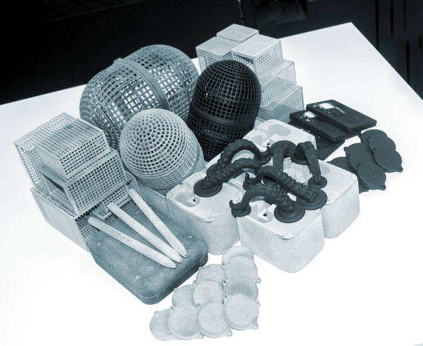 Veel verschillende modellen afgedrukt op 3D printer. Grijze en zwarte objecten afgedrukt - Foto, afbeelding