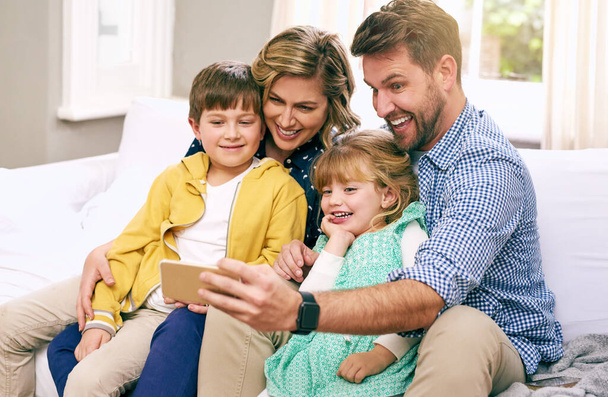 Είμαστε το είδος της οικογένειας που παίρνει συνεχώς selfies. Φωτογραφία μιας οικογένειας που βγάζει selfie στο σπίτι. - Φωτογραφία, εικόνα
