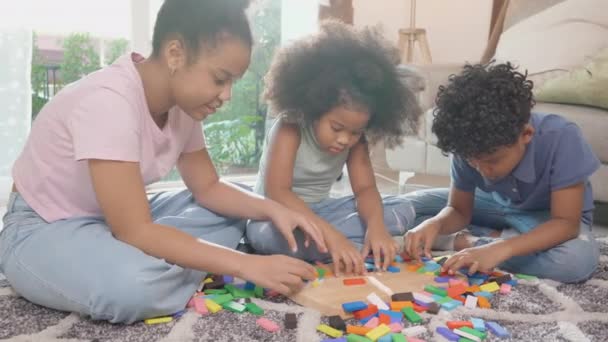 Ευτυχία οικογένεια με παιδιά παίζουν μπλοκ ξύλο στο πάτωμα μαζί με διασκέδαση και να χαλαρώσετε στο σαλόνι στο σπίτι, δραστηριότητα και χόμπι για τον ανταγωνισμό και τη μάθηση της ανάπτυξης, τον τρόπο ζωής έννοια. - Πλάνα, βίντεο