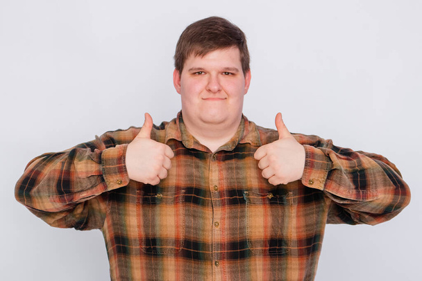 Fat guy showing thumbs up with both hands isolated on white background. Young man making a gesture, I like it, great job. Body language, body positivity. - Photo, image