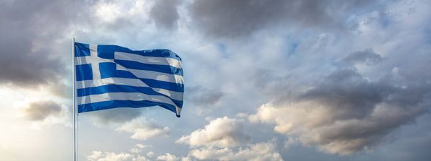 Yunanistan 'ın işareti. Rüzgarda dalgalanan bayrak direğindeki Yunan ulusal bayrağı. Bulutlu gökyüzü, bayrak - Fotoğraf, Görsel