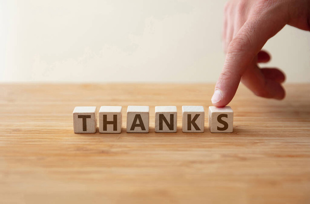 Thanks concept. Word thanks on wooden cube with finger to shows letter s. Message as gratitude, encourage, appreciation for care, help, hope, achievement, positive expression. - Foto, Imagen